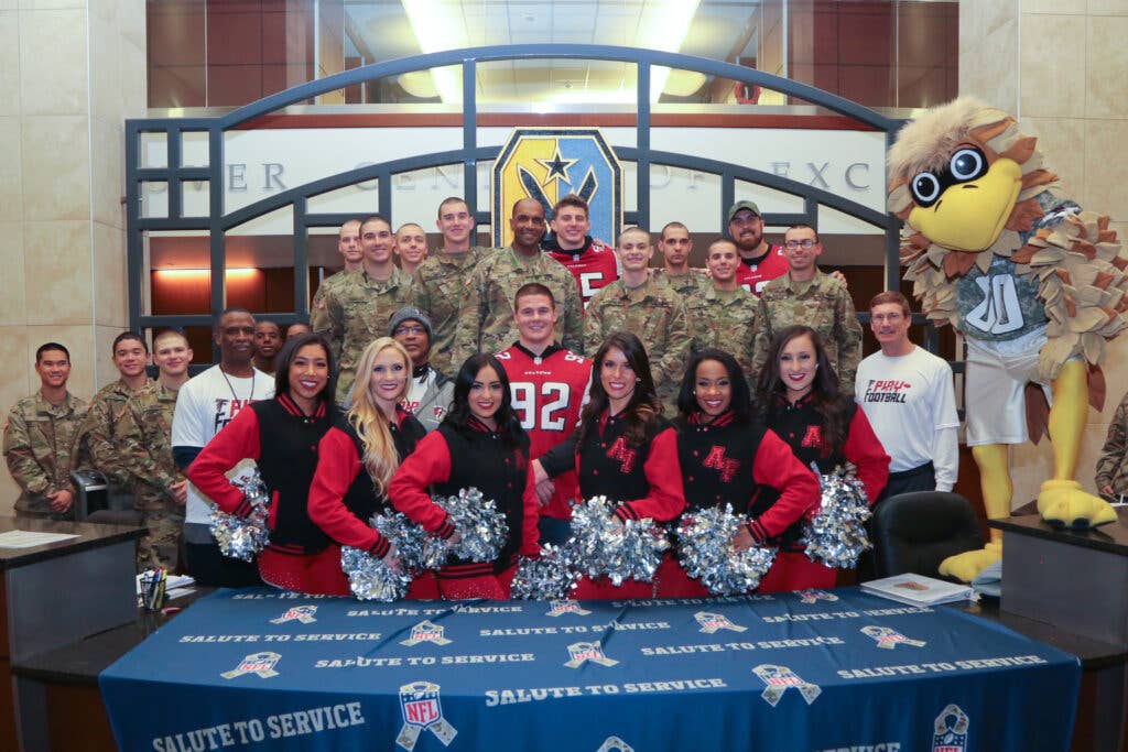 Maj. Gen. Gary Brito, commanding general, U.S. Army Maneuver Center of Excellence, poses with Fort Benning Soldiers, and Atlanta Falcons players, cheerleaders and staff during the NFL Salute to Service at McGinnis-Wickham Hall, Fort Benning, Georgia Jan. 29, 2019. (U.S. Army photo by Markeith Horace)