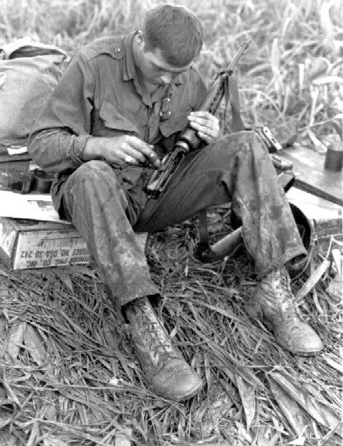 soldier cleaning his m16 in vietnam
