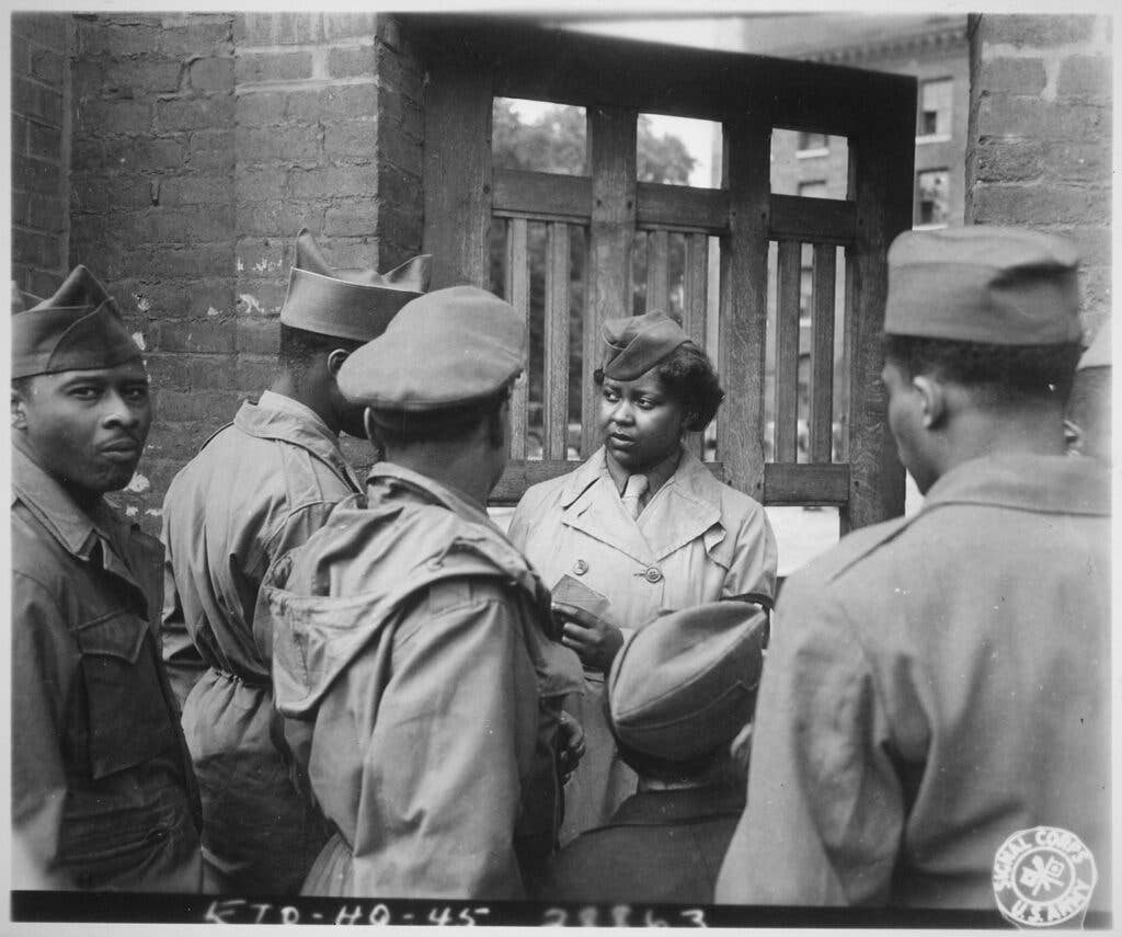 <br><em>"The first Negro WACs to arrive [on] the continent of Europe were 800 girls of the 6888th Central Postal Directory Bn, who had also been the first to arrive in England. After the battalion had set up its facilities at Rouen, France, it held an `open house', which was attended by hundreds of Negro soldiers. Pvt. Ruth L. James,...of the battalion area is on duty at the gate."</em> <br>Department of Defense photo/caption.