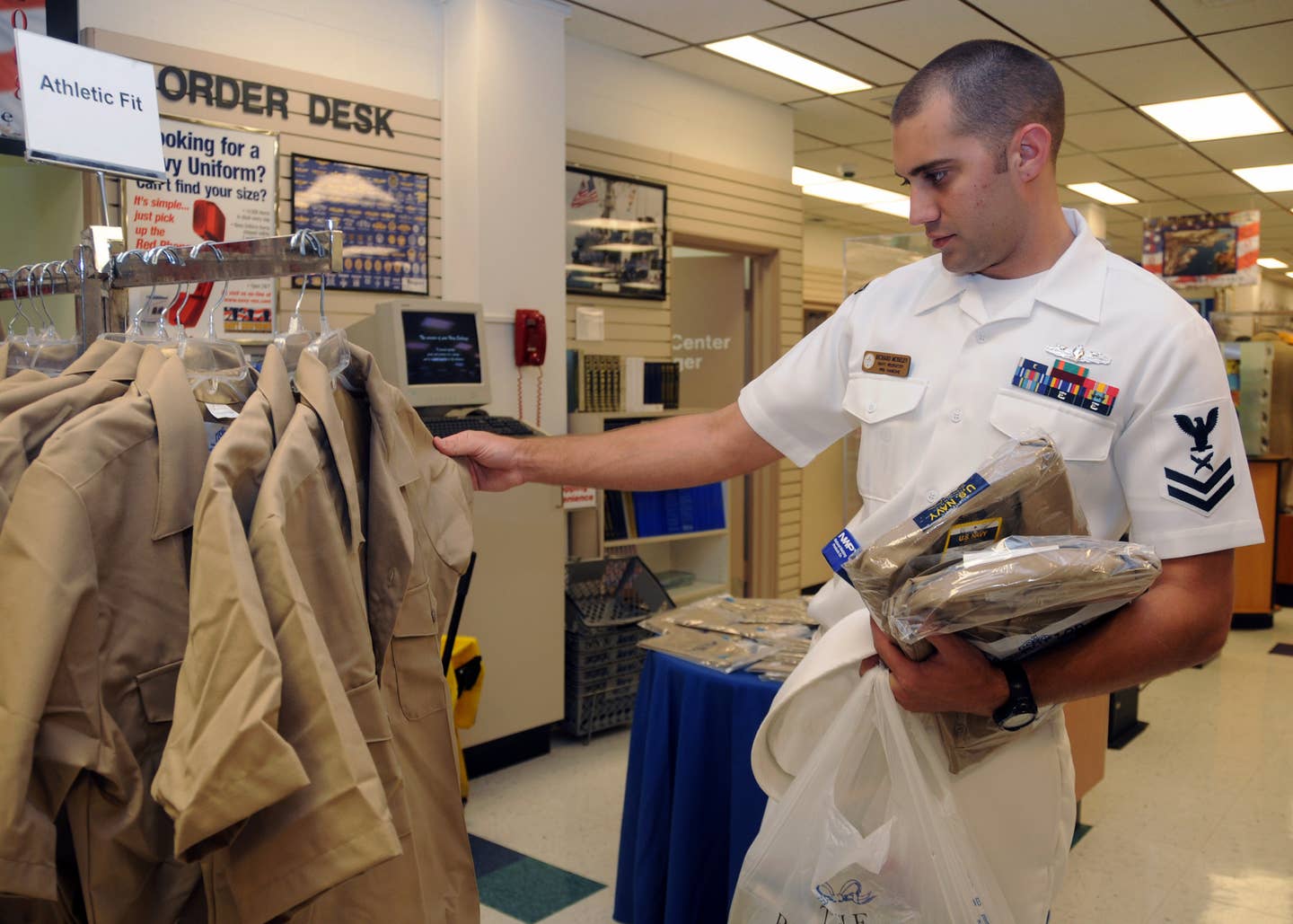 Yeoman Petty Officer 2nd Class Richard Moseley, assigned to Navy Recruiting Station Kaneohe, shops for the new service uniform at the Navy Exchange Uniform Shop aboard Naval Station Pearl Harbor.