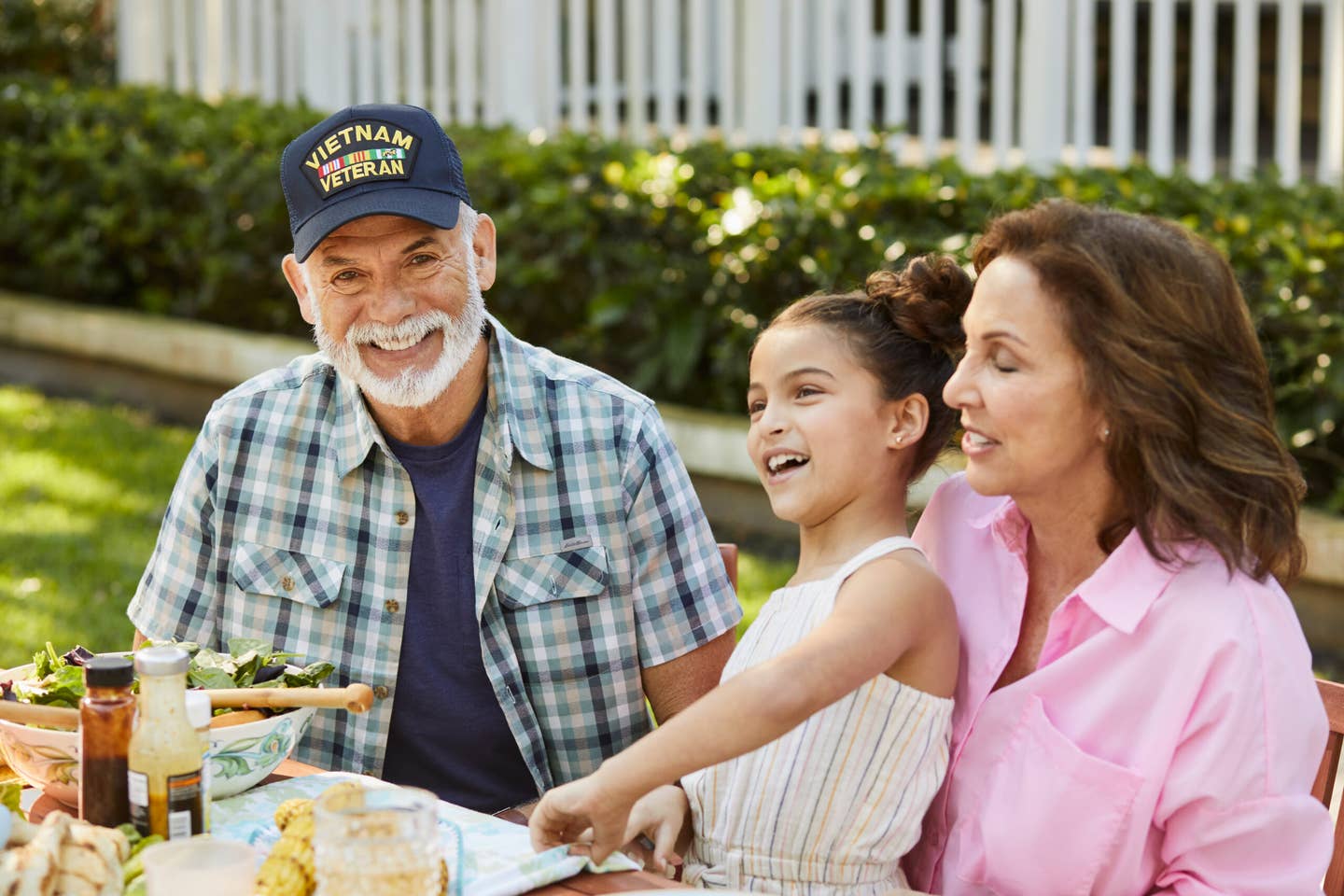 Active veteran sitting at a picnic outside with family.