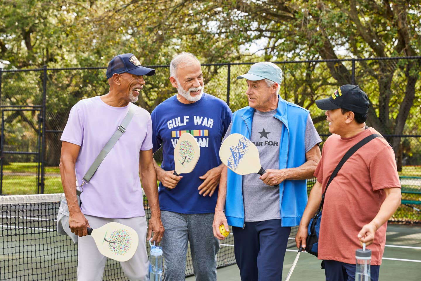Active veterans playing pickleball and laughing.