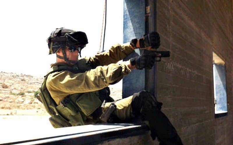 IDF special operations soldier aiming Israeli carry pistol through window.