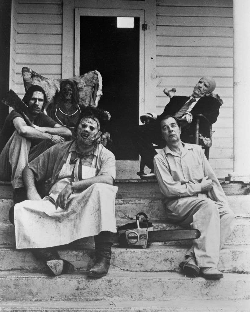 Horror movie villains from Texas Chainsaw massacre sitting on a porch.
