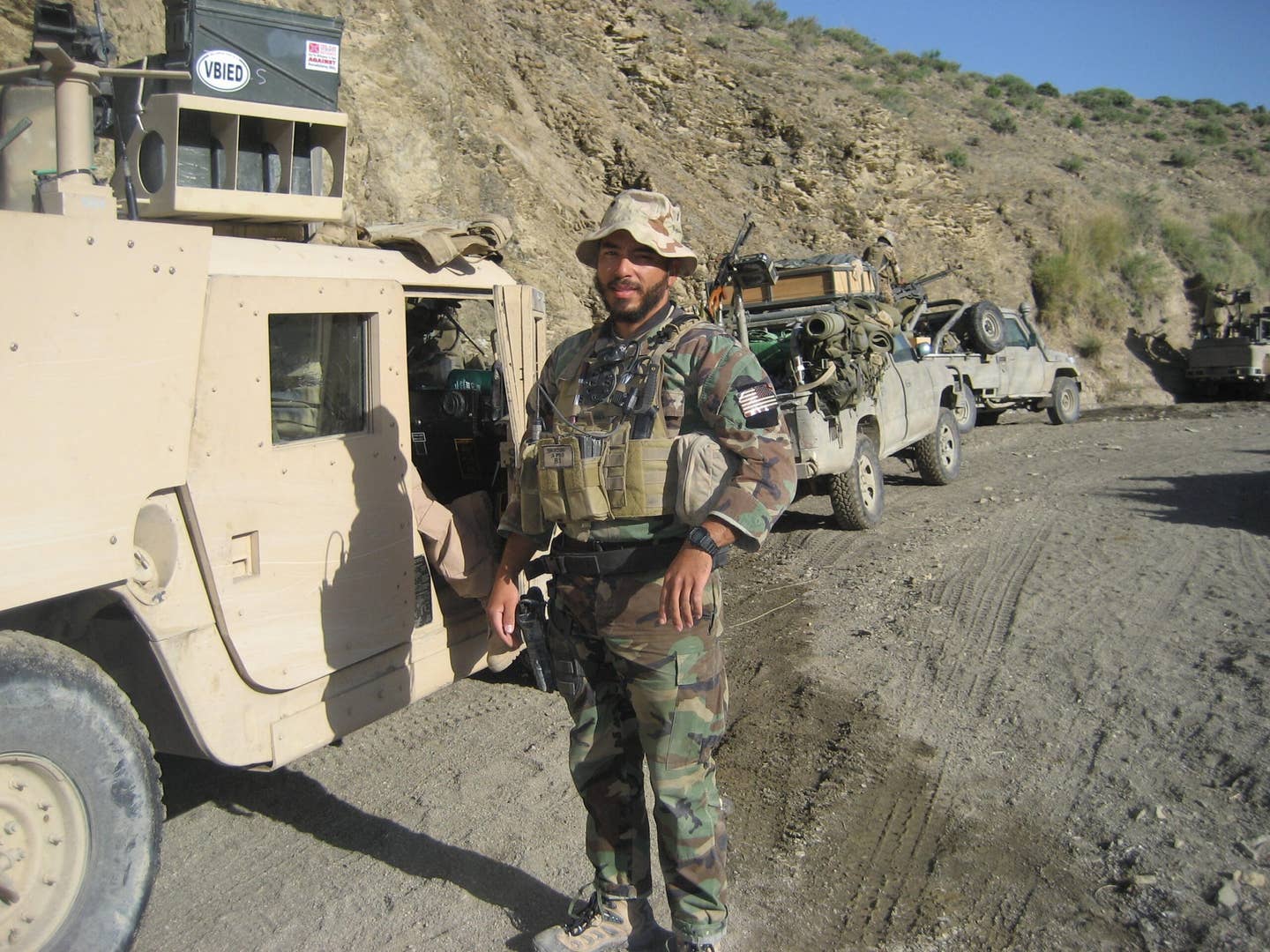 Green Beret Ruben Ayala standing in front of humvee.