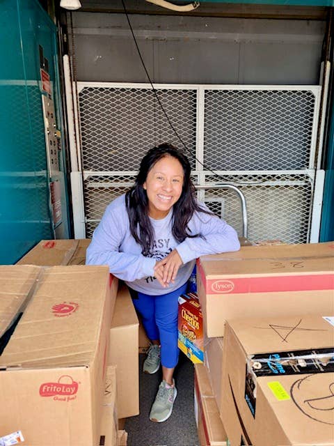 Monica Bassett standing next to boxes and smiling.