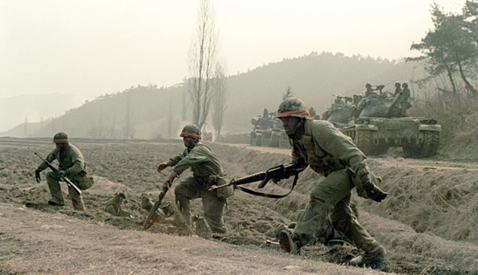 Members of Company C, 1ST Battalion, 5th Infantry, 25th Infantry Division, move out to attack opposing forces. Public domain