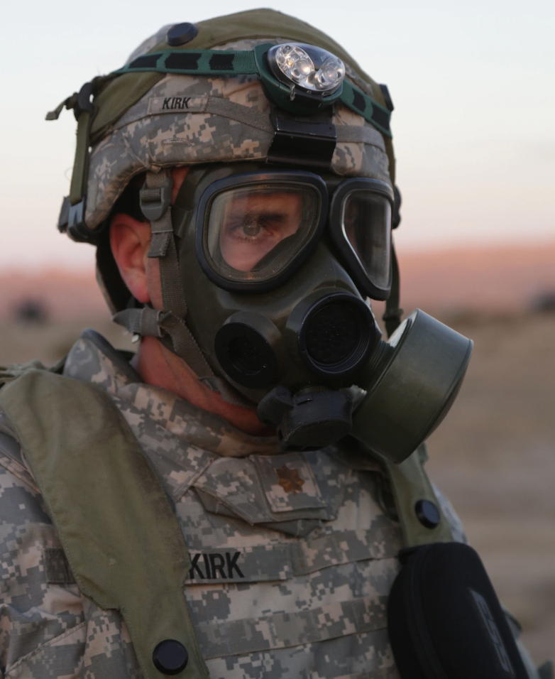A U.S. Army Soldier assigned to the 3rd Battalion, 501st Aviation Regiment, Combat Aviation Brigade, 1st Armored Division, reacts to a simulated chemical attack during Decisive Action Training Exercise,