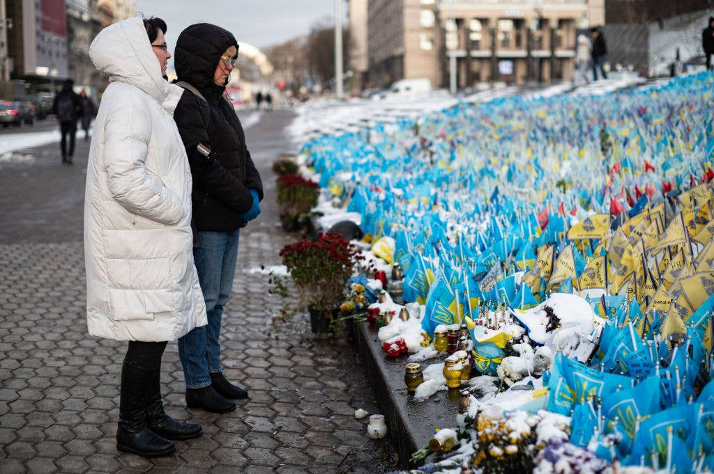 KYIV, UKRAINE - NOVEMBER 27: People stand around a memorial to fallen Ukrainian soldiers after a snowfall on November 27, 2023 in Kyiv, Ukraine. (Photo by Danylo Antoniuk/Global Images Ukraine via Getty Images)