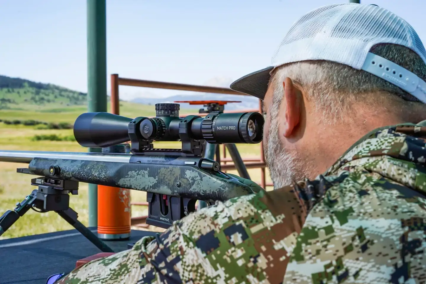 A man looks through a scope on a rifle