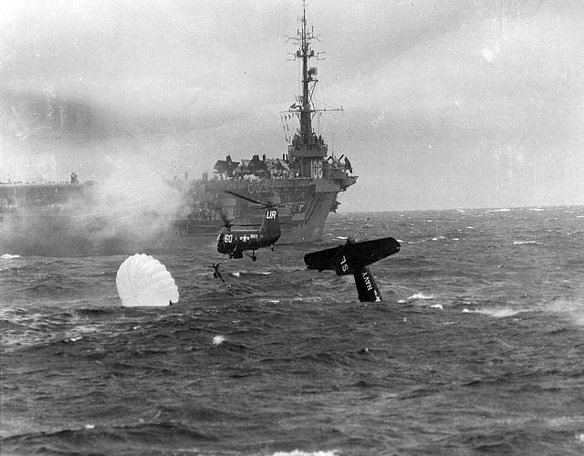 Recovery of the Ensign E.H. Barry, pilot of a U.S. Navy Grumman AF-2 Guardian from Anti-Submarine Squadron 22 (VS-22) by a Piasecki HUP helicopter after the plane was forced to ditch immediately after launching in 1953. The parent escort carrier USS Block Island (CVE-106) is standing by in the background. Public Domain. 