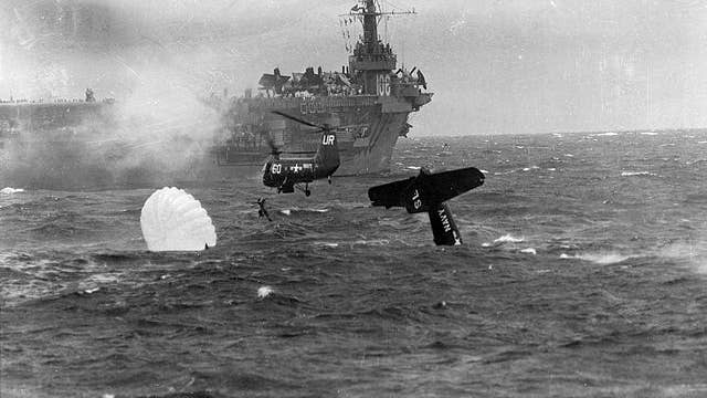 Recovery of the Ensign E.H. Barry, pilot of a U.S. Navy Grumman AF-2 Guardian from Anti-Submarine Squadron 22 (VS-22) by a Piasecki HUP helicopter after the plane was forced to ditch immediately after launching in 1953. The parent escort carrier USS Block Island (CVE-106) is standing by in the background. Public Domain. 