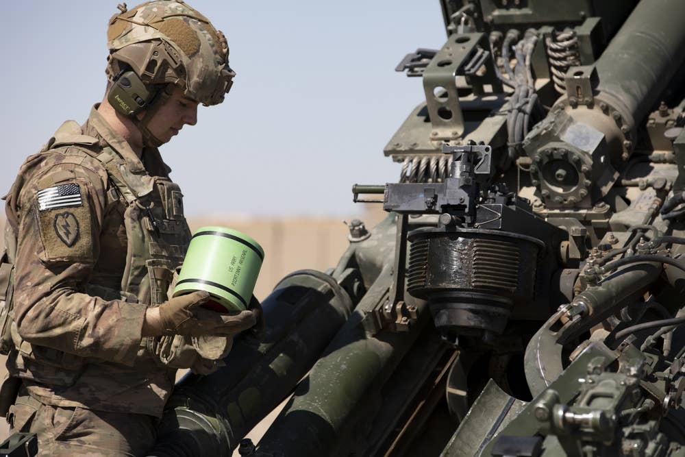<em>A soldier loads a primer into an M777 (U.S. Army)</em>