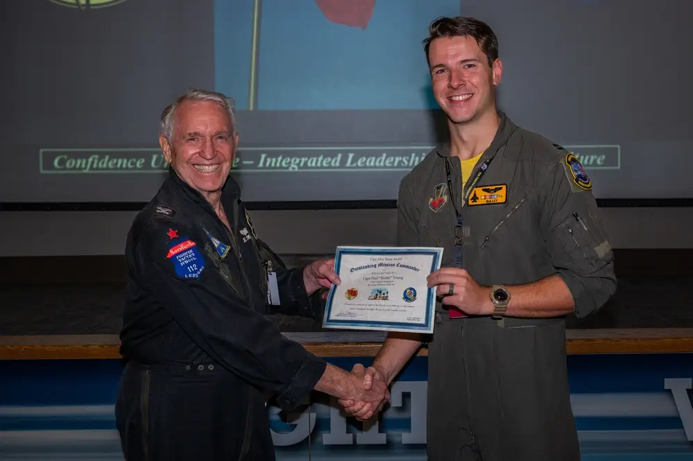 Capt. Paul Young, a pilot assigned to the 336th Fighter Squadron, Seymour Johnson, accepts the Capt. John Stone award for ‘Outstanding Mission Commander’ by its namesake, retired Col. John “JB” Stone, during the Red Flag-Nellis 22-3 culmination ceremony at Nellis Air Force Base, Nevada, July 28, 2022. The Capt. John Stone award is the mark of influential and quintessential planning that will lead the Air Force into surpassing its near-peer challengers. (U.S. Air Force photo by Airman 1st Class Josey Blades)