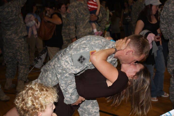 Corie Weathers kisses her husband at a homecoming ceremony.
