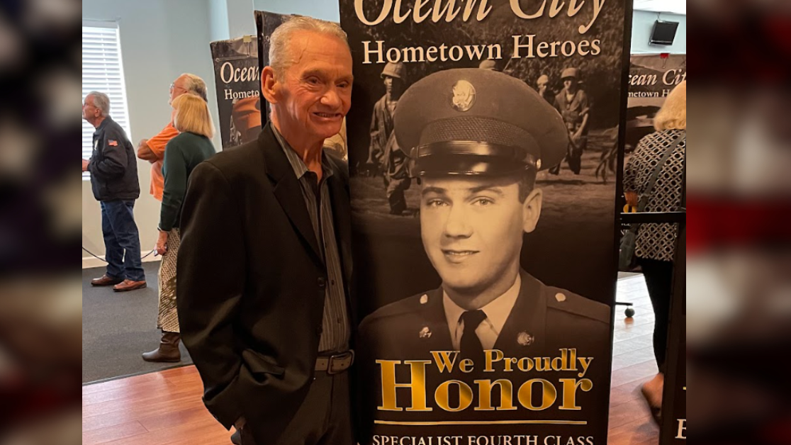 David McAllister stands next to a banner honoring his Vietnam service. Photo courtesy of Matt McAllister.