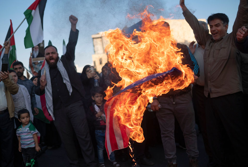 Protestors in Iran burn an American flag.