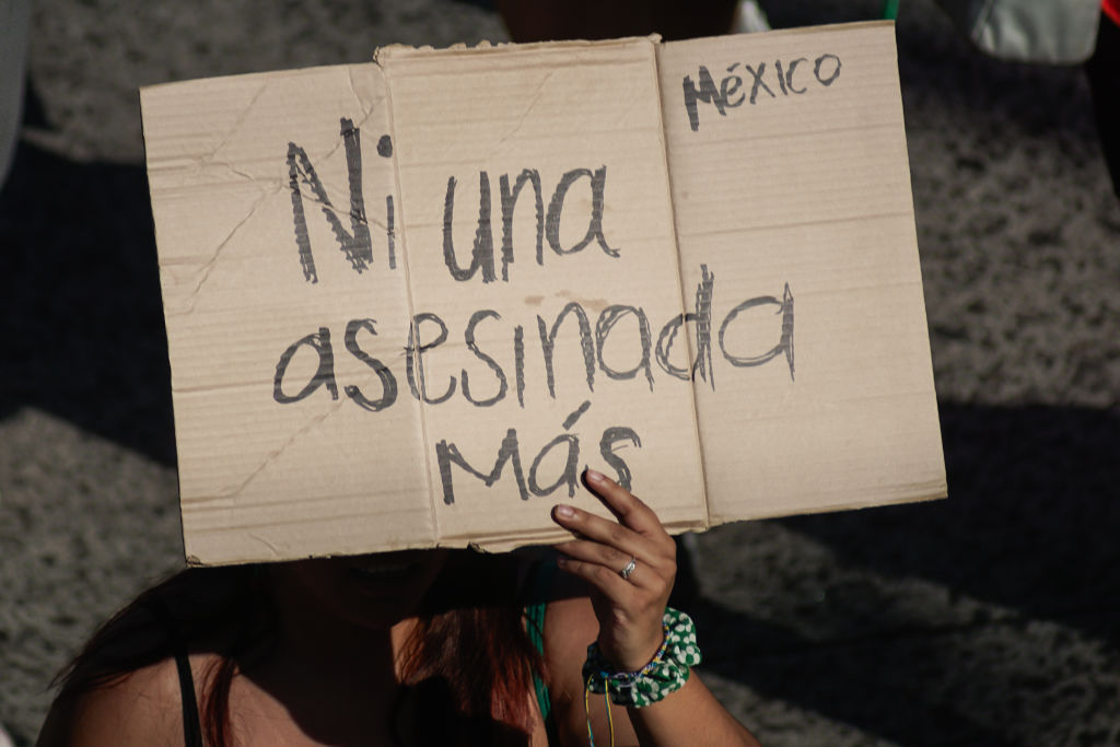 SAN SALVADOR, EL SALVADOR - NOVEMBER 25: A feminist woman from Mexico walks holding up a cardboard sign with the legend "Not one more assassinated" during a demonstration to mark International Day For The Elimination Of Violence Against Women on November 25, 2023 in San Salvador, El Salvador. (Photo by APHOTOGRAFIA/Getty Images)