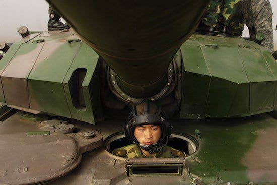 A Chinese tanker soldier with the People's Liberation Army sits while the Chairman of the Joint Chiefs of Staff comes aboard his tank at Shenyang training base, China, Mar. 24, 2007. (Photo: U.S. Department of Defense Staff Sgt. D. Myles Cullen)