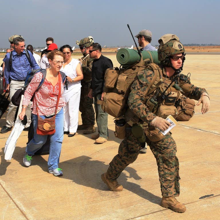 Marines guide U.S. citizens down the flight line in Juba, South Sudan, during an evacuation of personnel from the U.S. Embassy, Jan. 3, 2014. Photo: US Marine Corps Staff. Sgt. Robert L. Fisher III