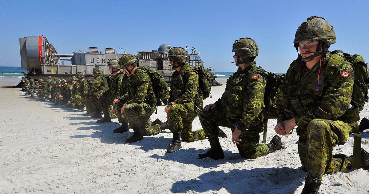 Canadian soldiers set a perimeter position after disembarking a U.S. Navy landing craft during a simulated amphibious landing. (Photo: Wikimedia)