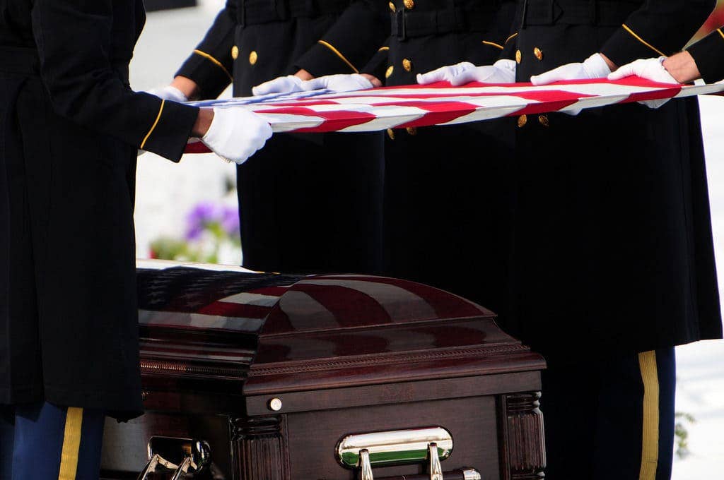 Soldiers from The Old Guard fold the American flag over the casket of a fallen soldier. (U.S. Army photos by Staff Sgt. Luisito Brooks)