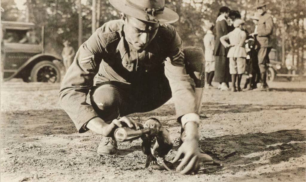 A World War I soldier plays with the unit mascot at Camp Wadsworth near Spartansburg, South Carolina. (Photo: National Archives and Records Administration)