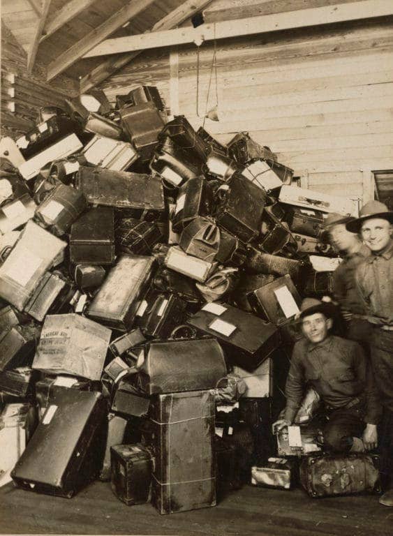 Soldiers finished with stateside training pose next to the large pile of luggage destined for their homes as they ship overseas. (Photo: National Archives and Records Administration)