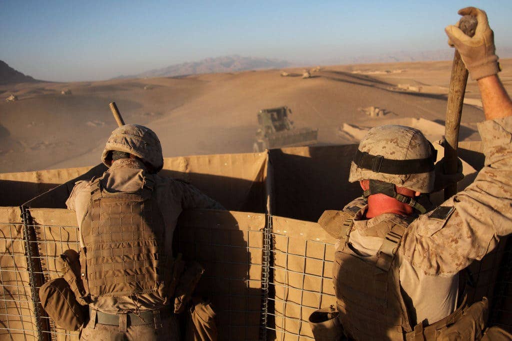 Marines from 1st CEB, fill Hesco barriers at a combat outpost in Musa Qaleh, Afghanistan. (Photo via <a href="http://www.1stmardiv.marines.mil/News/News-Article-Display/Article/541344/marine-engineers-build-outpost-after-clearing-insurgents-from-town/" target="_blank" rel="noreferrer noopener">1stMarDiv</a>)