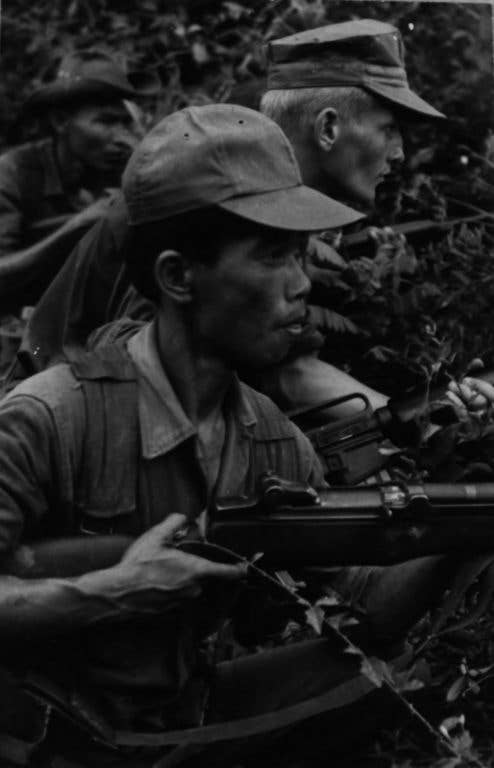 A Vietnamese Popular Force soldier and U.S. Marine Cpl. Gilbert J. Davis practice ambush techniques outside the compound of Mobile Training Team-1 near Tam Ky on July 28, 1968. The Vietnamese received two weeks of Marine training. (Photo: U.S. Marine Corps 1st Lt. Joe Collins)