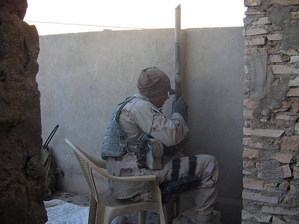 Peeples peers over a wall to identify an enemy sniper position. (Photo courtesy of Adam Peeples)