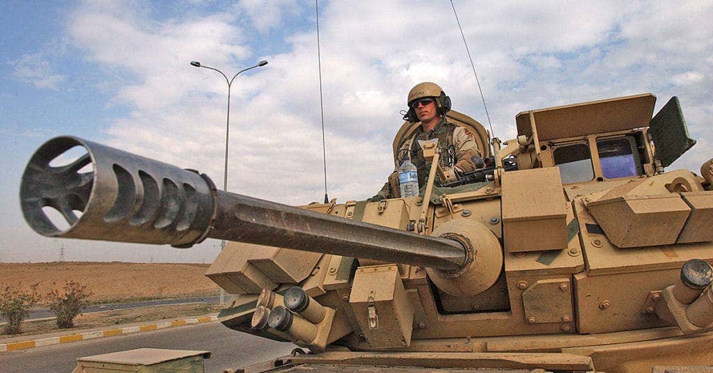 A Task Force Liberty Soldier from 3rd Infantry Division stands guard in an M3A3 Bradley Fighting Vehicle near an Iraqi police checkpoint in Tikrit, Iraq. The Bradley main armament is the M242 25mm (Bushmaster) Chain Gun. The standard rate of fire is 200 rounds per minute, and has a range of 2,000 meters making it capable of defeating the majority of armored including some main battle tanks. (DOD photo)