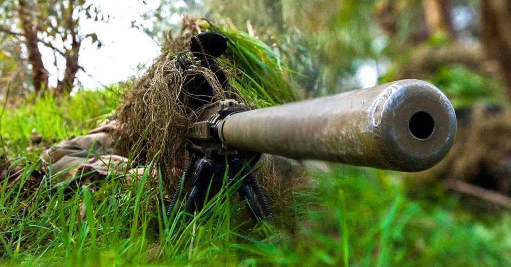 After crawling through grass and brush toward their target, a sniper team from Headquarters and Headquarters Company, 1-36 Infantry Division, attached to the 3rd Infantry Division, set their sights on their target during a two-week training school where U.S. Soldiers trained Iraqi army special forces at the Al Kindi Iraqi army base in Mosul, Iraq.