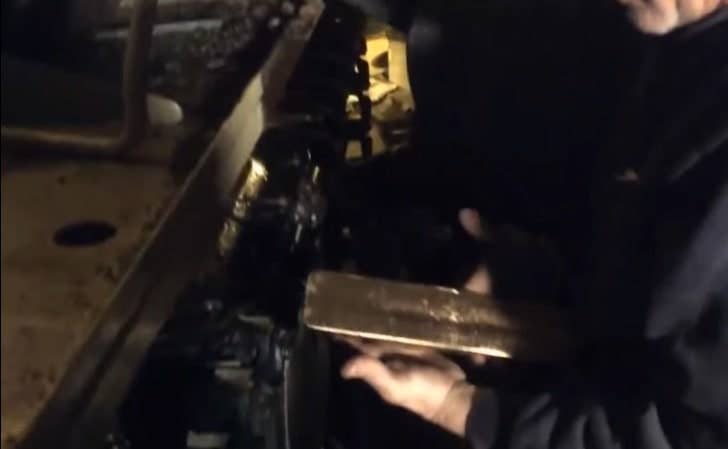 Nick Mead holds one of the gold bars he discovered when checking out the Type 69 tank he bought on eBay. (Youtube screenshot)
