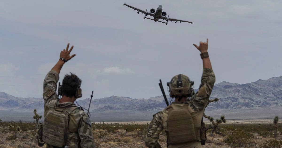Joint terminal attack controllers wave at an A-10 Thunderbolt II attack aircraft during a show of force on the Nevada Test and Training Range July 19, 2017. The A-10 has excellent maneuverability at low airspeeds and altitudes and is a highly accurate weapons delivery platform. (U.S. Air Force photo by Senior Airman Kevin Tanenbaum)