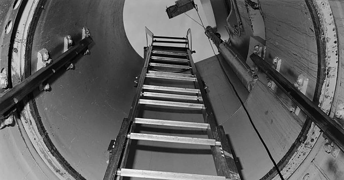 A ladder extends into a 28-foot-deep shaft toward the equipment room that encircles the upper part of an underground missile silo. Image from Library of Congress.