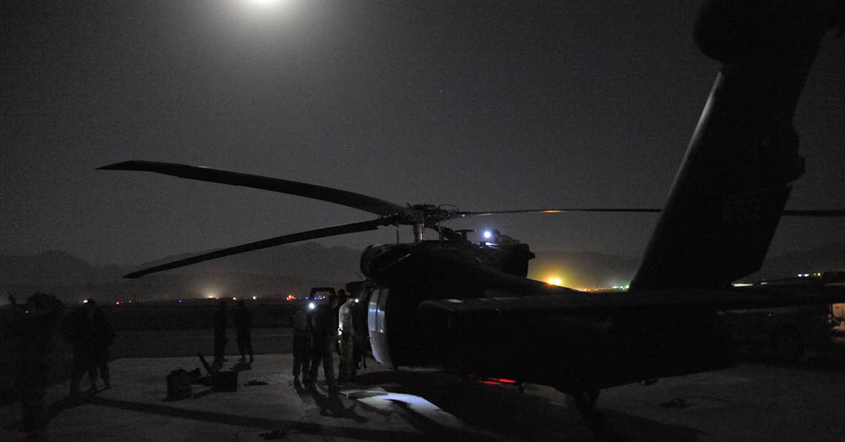 On Camp Marmal in Afghanistan, Blackhawk crew members from the 12th Combat Aviation Brigade's Alpha Company 5th Battalion 158th Aviation perform after-operations checks on their UH-60 Blackhawk helicopter following night-operations in RC-North. US Army Photo by Capt. Michael Barranti.