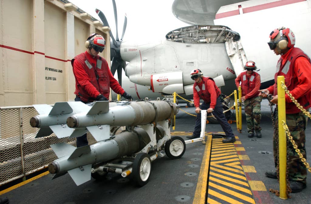 Aviation Ordnancemen place a weapons cart of GBU-38 500-pound satellite guided bombs on an ordnance elevator on the flight deck of the Nimitz-class aircraft carrier USS Theodore Roosevelt (CVN 71). The bombs are prepared in a ship's magazine, and then lifted up to the flight deck. (U.S. Navy photo by Photographer's Mate Airman Stephen Early)