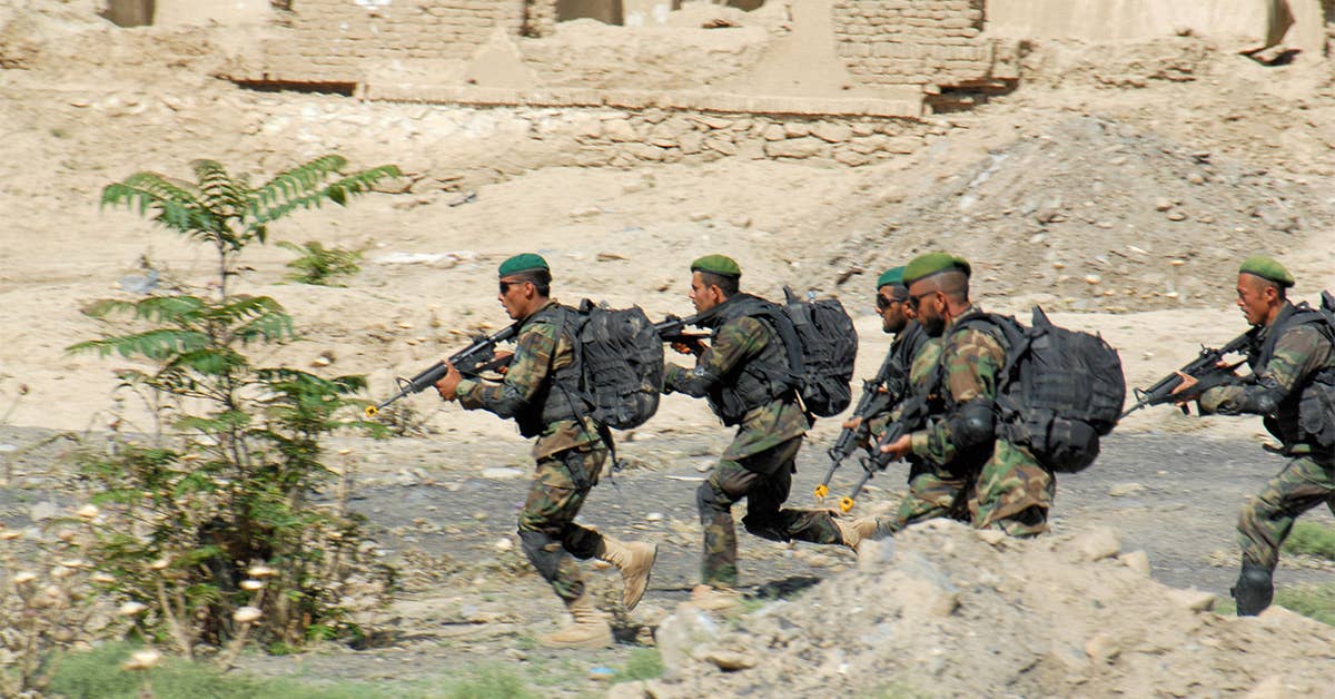 Afghan National Army soldiers assault a building during their final training exercise in Kabul, Afghanistan. (Navy Photo by Petty Officer 1st Class Scott Cohen.)