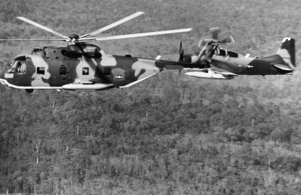 An A-1 Skyraider escorts an HH-3C rescue helicopter as it goes in to pick up a downed pilot in Vietnam. (National Museum of the USAF Photo)