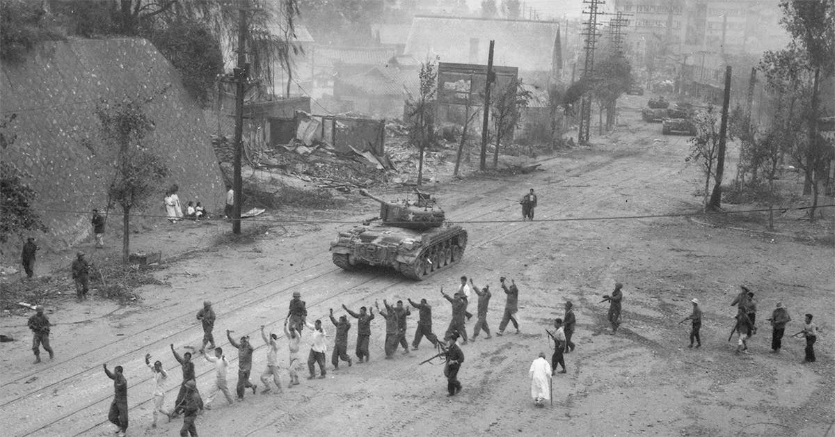 American M26 Pershing tanks in downtown Seoul, South Korea, in the Second Battle of Seoul during the Korean War. In the foreground, United Nations troops round up North Korean prisoners-of-war. Photo from the Naval Historical Center.