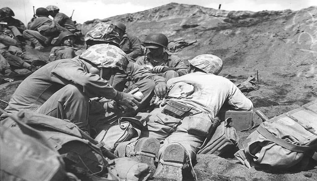 U.S. Navy Corpsman dressing the back wound of a Marine who was hit by the enemy in the battle of Iwo Jima. (February 1945.)