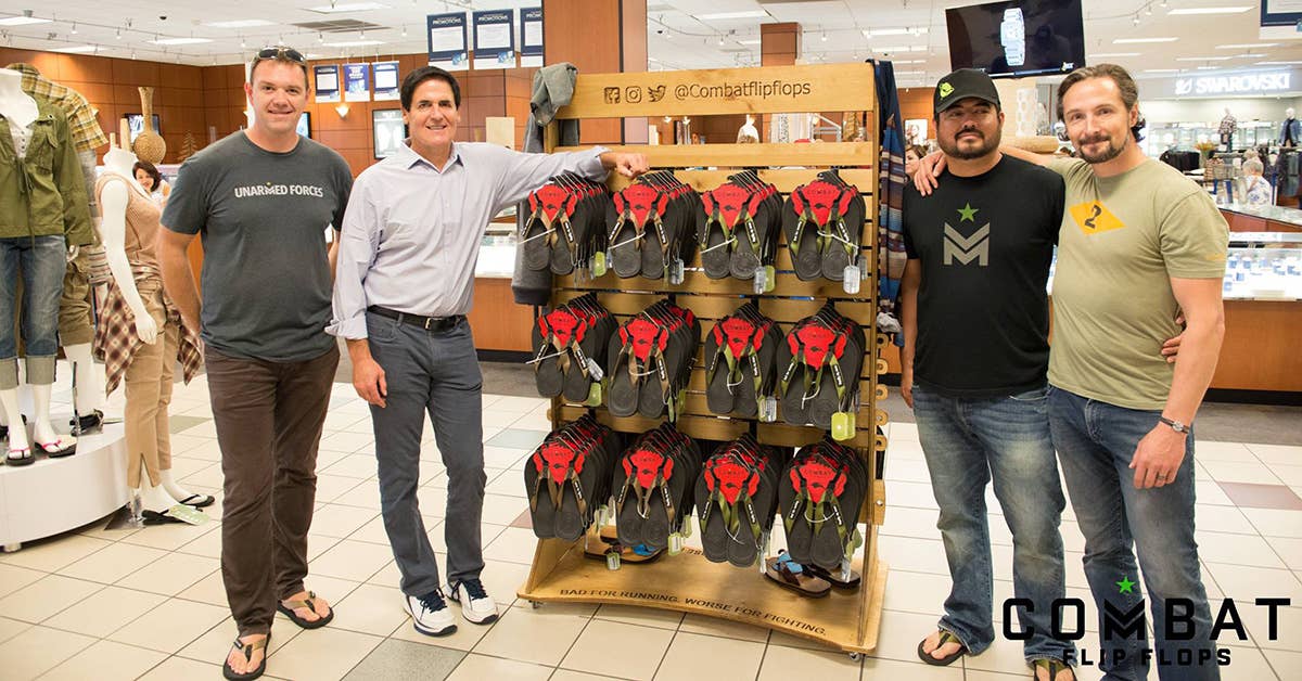 The Combat Flip Flops team and Mark Cuban (button shirt) pose by some product. Photo from Combat Flip Flops Facebook.