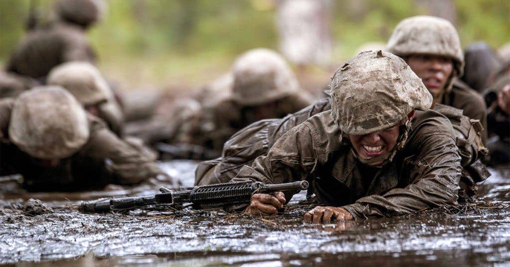 These recruits crawl through the nasty mud in order to reach their goal of earning the title of U.S. Marine during Crucible training.