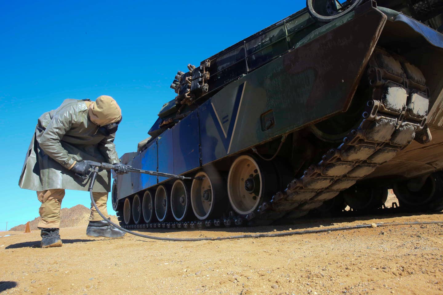 Lance Cpl. Michael Pleminski, tank maintainer, 1st Tank Battalion, decontaminates an M1A1 Abrams Main Battle Tank during 1st Tanks' operational decontamination training on Bearmat Hill, March 10, 2016. 1st Tanks held the exercise to sharpen its skills decontaminating tanks, tactical vehicles, and personnel who are exposed to Chemical, Biological, Radiological and Nuclear contaminants. (Official Marine Corps photo by Cpl. Julio McGraw)