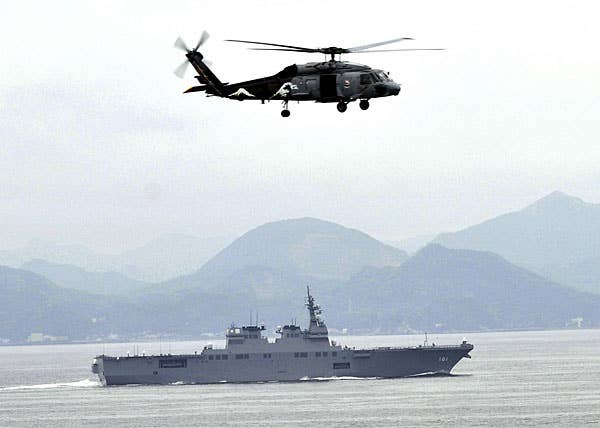 An SH-60 Sea Hawk helicopter flies near the Japan Maritime Self-Defense Force helicopter destroyer JS Hyuga. (U.S. Navy photo by Seaman Danielle A. Brandt)