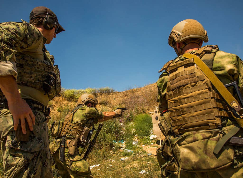A U.S Naval Special Warfare Operator observes a Ukrainian SOF Operator during a weapons range in Ochakiv, Ukraine during exercise Sea Breeze 17, July 18, 2017.