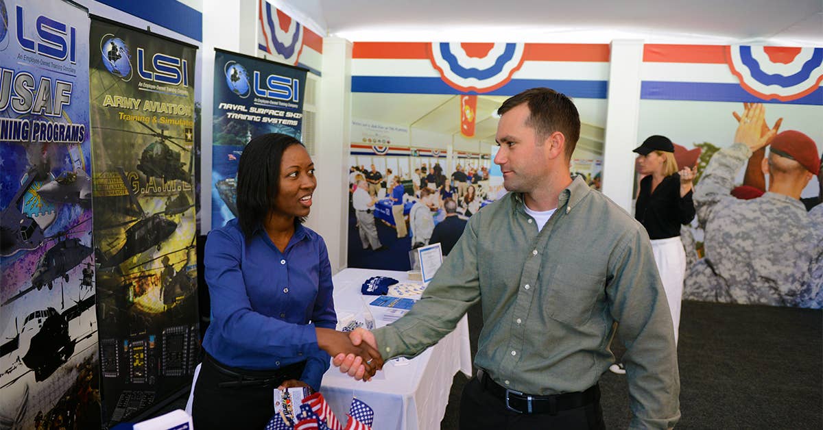 Kerry-Ann Moore, left, an advisor from the Jacksonville Military Affairs and Veterans Department, shakes hands with Army Capt. Jessie Felix during a military job fair in Ponte Vedra Beach, Florida, May 2, 2015. (DoD photo by Army Sgt. 1st Class Tyrone C. Marshall Jr.)