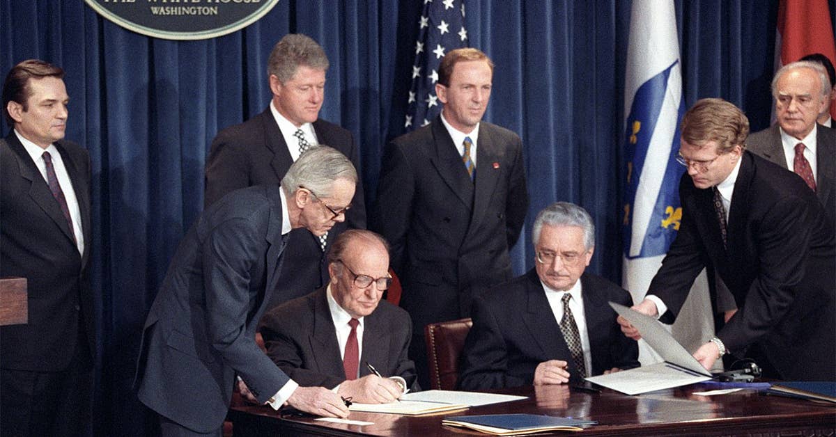 Bosnian President Alija Izetbegovic (seated, left) and Croatian President Franjo Tudjman (seated, right) sign the Croat-Muslim Federation Peace Agreement in the Old Executive Office Building, March 18, 1994. (Photo courtesy of the William J. Clinton Presidential Library)