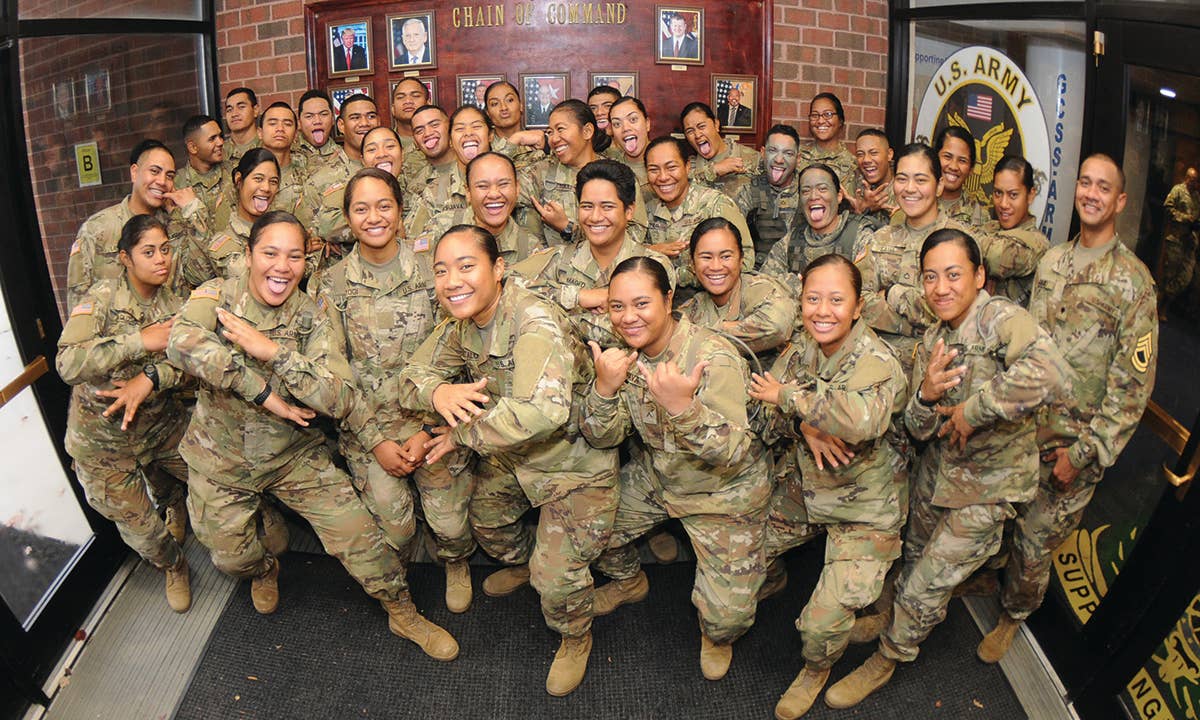 More than 30 members of an American Samoa family pose for pictures by contorting their faces and posturing for a traditional dance Nov. 8 at Thompson Hall. (U.S. Army photo by T. Anthony Bell)